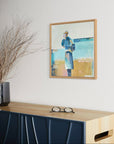 Framed artwork of a woman in a blue dress on a wall above a console table with decorative elements.